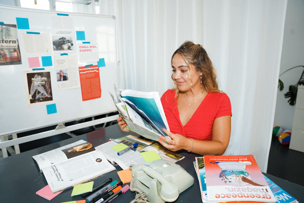 getpress Mitarbeiterin Adriana sitzt am Schreibtisch und liest